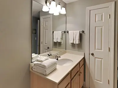 a bathroom with a sink and a mirror and towels at Twin Palms #1805A in Panama City Beach