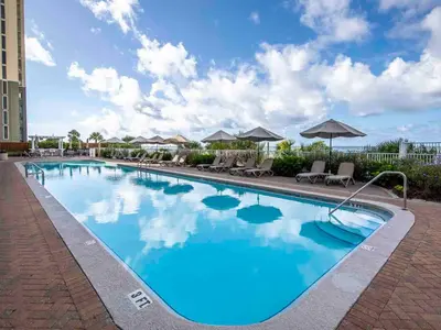 a pool at a hotel with chairs and umbrellas at Twin Palms #1805A in Panama City Beach