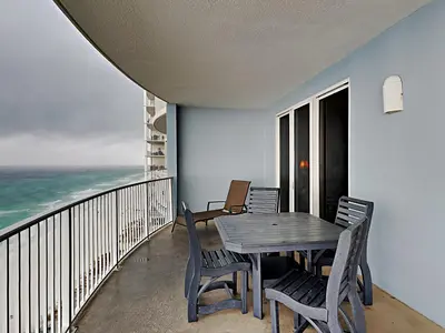 a dining room with a table and chairs on a balcony at Twin Palms #1805A in Panama City Beach