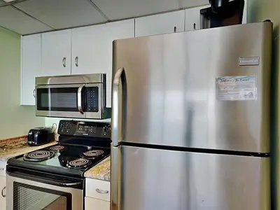 a stainless steel refrigerator in a kitchen with a microwave at Long Beach Resort Tower II #202 in Panama City Beach