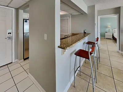 a kitchen with a counter and stools in a room at Long Beach Resort Tower II #305 in Panama City Beach
