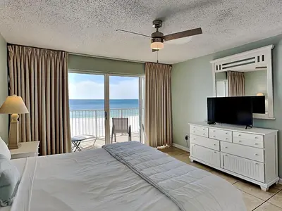 a bedroom with a bed and a television and a balcony at Long Beach Resort Tower II #305 in Panama City Beach
