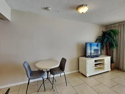 a dining room with a table and chairs and a tv at Long Beach Resort Tower III #402 in Panama City Beach