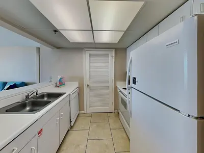 a kitchen with a sink and a refrigerator at Long Beach Resort Tower III #402 in Panama City Beach