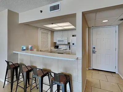 a kitchen with a bar with four stools in it at Long Beach Resort Tower III #402 in Panama City Beach