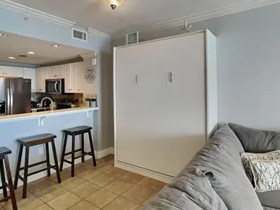 a living room with a couch and a kitchen at Majestic Beach Towers II #1902 in Panama City Beach