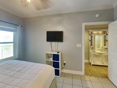 a bedroom with a bed and a tv on the wall at Majestic Beach Towers II #1902 in Panama City Beach