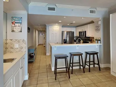 a kitchen with two bar stools and a counter top at Majestic Beach Towers II #1902 in Panama City Beach