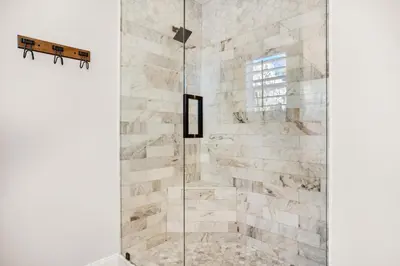 a shower with a glass door in a bathroom at The Sand Castle in Panama City Beach