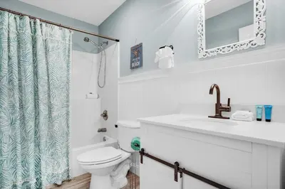 a white bathroom with a toilet and a sink at The Sand Castle in Panama City Beach