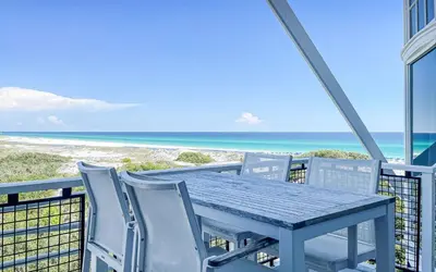 a table and chairs on a balcony with the beach at GULF FRONT PENTHOUSE CONDO COMPLIMENTARY GOLF CART 407 Compass Point 1, WaterSound - 3 BR, SLPS 8 condo in Panama City Beach