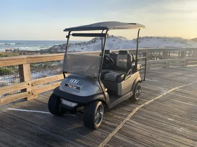 a golf cart parked on a pier near the beach at GULF FRONT PENTHOUSE CONDO COMPLIMENTARY GOLF CART 407 Compass Point 1, WaterSound - 3 BR, SLPS 8 condo in Panama City Beach