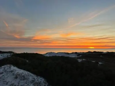 a sunset over the ocean with trees and the sky at GULF FRONT PENTHOUSE CONDO COMPLIMENTARY GOLF CART 407 Compass Point 1, WaterSound - 3 BR, SLPS 8 condo in Panama City Beach