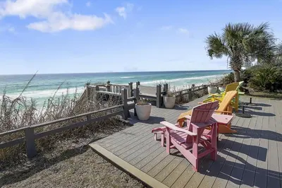a wooden deck with chairs on the beach at Gulf Front Home in Seagrove Beach, FL with 3 Bedrooms and 3 Bathrooms home in Santa Rosa Beach