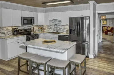 a kitchen with a refrigerator and a counter with stools at Gulf Front Home in Seagrove Beach, FL with 3 Bedrooms and 3 Bathrooms home in Santa Rosa Beach