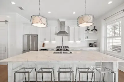 a kitchen with a large white island with bar stools at Private Pool and Short Walk to the Beach - Seagrove Beach FL home in Santa Rosa Beach