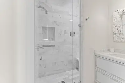 a white bathroom with a shower and a sink at Enchantment - Beach Front, Private Pool, Private Beach Access - 5BR 5BTH Home home in Panama City Beach