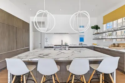 a kitchen with a large island with white bar stools at Enchantment - Beach Front, Private Pool, Private Beach Access - 5BR 5BTH Home home in Panama City Beach