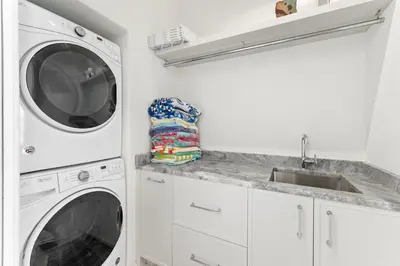 a white laundry room with a washer and dryer at Enchantment - Beach Front, Private Pool, Private Beach Access - 5BR 5BTH Home home in Panama City Beach