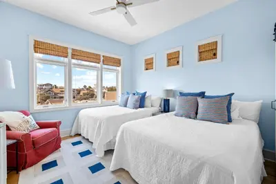 a blue bedroom with two beds and a red chair at GULF VIEWS from ALL Bedrooms! 308 Compass Point 1 in WaterSound - Short walk to the beach and pool condo in Panama City Beach