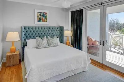 a bedroom with a bed with a blue headboard at Spacious, Gulf Views 110B WaterSound Crossings Steps to Beach and Pool condo in Panama City Beach