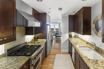 a kitchen with wooden cabinets and a stove top oven at Spacious, Gulf Views 110B WaterSound Crossings Steps to Beach and Pool condo in Panama City Beach