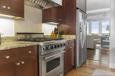 a kitchen with a stainless steel stove and wooden cabinets at Spacious, Gulf Views 110B WaterSound Crossings Steps to Beach and Pool condo in Panama City Beach