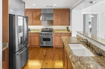 a kitchen with a stainless steel refrigerator and wooden cabinets at BEAUTIFUL GULF VIEWS Spacious, Updated 316B WaterSound Crossings Steps to Beach and Pool condo in Panama City Beach