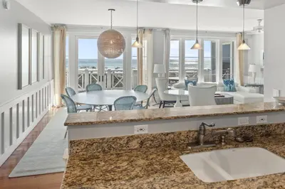 a kitchen and dining room with a table and chairs at BEAUTIFUL GULF VIEWS Spacious, Updated 316B WaterSound Crossings Steps to Beach and Pool condo in Panama City Beach