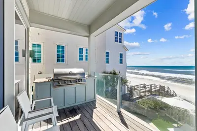 a patio with a grill and a view of the beach at Gulf Front Luxurious Home with Private Pool and Beach Access home in Panama City Beach