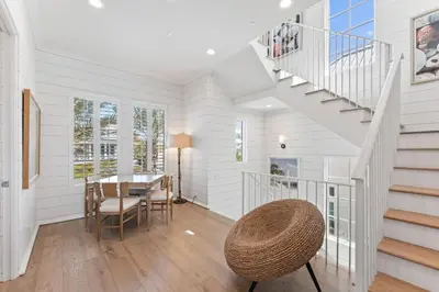 a dining room with a staircase and a table at Gulf Front Luxurious Home with Private Pool and Beach Access home in Panama City Beach
