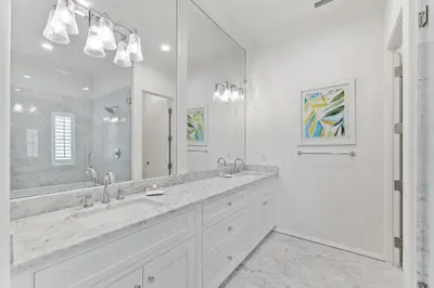 a white bathroom with two sinks and a large mirror at Gulf Front Luxurious Home with Private Pool and Beach Access home in Panama City Beach
