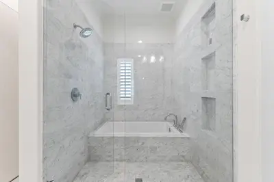 a white bathroom with a tub and a shower at Gulf Front Luxurious Home with Private Pool and Beach Access home in Panama City Beach