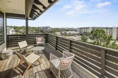 a balcony with chairs and tables and a view of a city at Gulf Views, Private Pool, Luxurious Home - Vista Del Mare home in Santa Rosa Beach