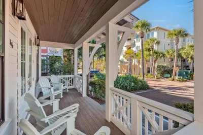 a porch with white chairs and palm trees at Luxurious 