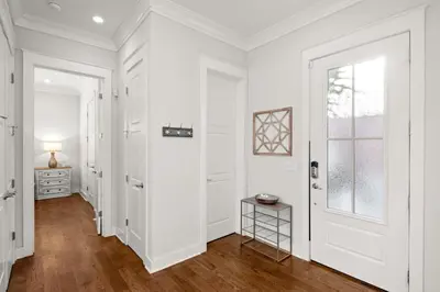 a white hallway with a door and a window at Luxurious 