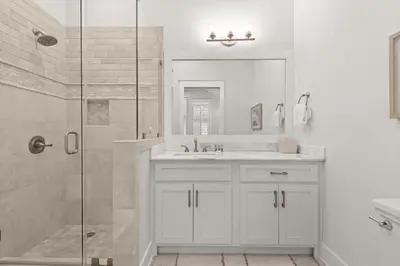 a white bathroom with a shower and a sink at Luxurious 