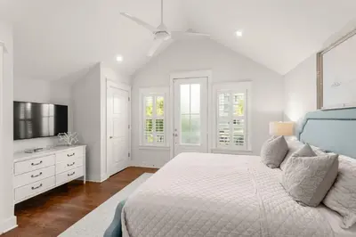 a white bedroom with a bed and a tv at Luxurious 
