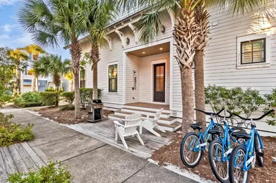 two bikes parked outside of a house with palm trees at Luxurious 