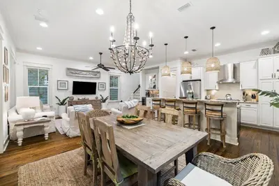 a kitchen and living room with a wooden table and chairs at Charming 4 BR Family Beach Retreat - 25 Half Moon, WaterSound West Beach home in Panama City Beach
