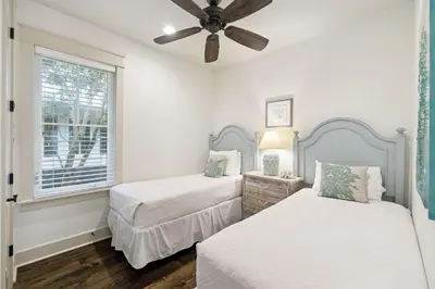 a bedroom with two beds and a ceiling fan at Charming 4 BR Family Beach Retreat - 25 Half Moon, WaterSound West Beach home in Panama City Beach