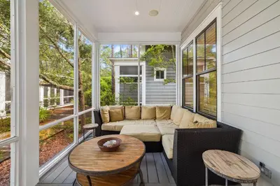 a screened in porch with a couch and a table at Charming 4 BR Family Beach Retreat - 25 Half Moon, WaterSound West Beach home in Panama City Beach