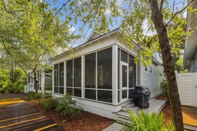 a white house with large glass doors on a deck at Charming 4 BR Family Beach Retreat - 25 Half Moon, WaterSound West Beach home in Panama City Beach