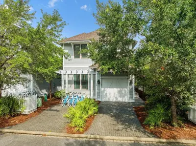 a white house with bikes parked in the driveway at Charming 4 BR Family Beach Retreat - 25 Half Moon, WaterSound West Beach home in Panama City Beach