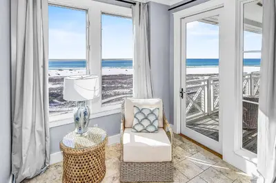 a living room with a chair and a view of the ocean at STUNNING GULF VIEWS - 3BR WaterSound Condo #426A - Steps to Beach and Pool condo in Panama City Beach