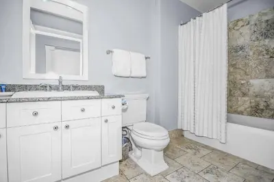 a white bathroom with a toilet and a sink at STUNNING GULF VIEWS - 3BR WaterSound Condo #426A - Steps to Beach and Pool condo in Panama City Beach