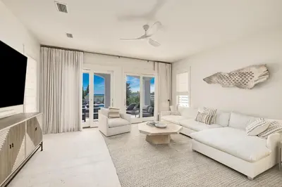 a living room with white furniture and a flat screen tv at Shellstone Cottage - Beach Front Seacrest Home with Private Pool and 5 Bedrooms home in Inlet Beach