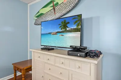 a flat screen tv sitting on top of a dresser at Anchors Away - Private Pool, Seasonal Hot Tub, Game Room, Walk to Beach, Pets OK in Panama City Beach