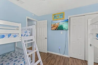 a bedroom with two bunk beds and a ladder at Anchors Away - Private Pool, Seasonal Hot Tub, Game Room, Walk to Beach, Pets OK in Panama City Beach