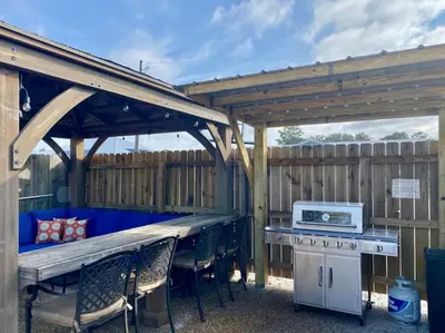 a picnic table and chairs under a wooden pergola at Anchors Away - Private Pool, Seasonal Hot Tub, Game Room, Walk to Beach, Pets OK in Panama City Beach